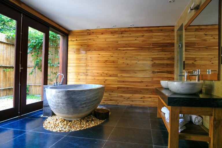 Elegant bathroom showcasing a modern marble tub and wooden interior for a serene escape.